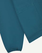 Close front flat shot of uskees mid-blue men's organic cotton smock showing elasticated cuff and front pocket