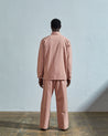 Back view of model wearing Uskees men's shirt jacket #3011 in dusty pink organic cotton showing reinforced elbows.