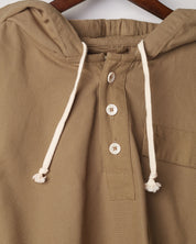 Close-up of khaki coloured buttoned smock from Uskees with focus on right breast pocket.
