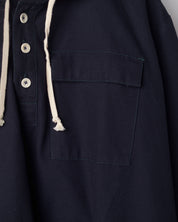 Close-up of midnight blue coloured buttoned smock from Uskees with focus on right breast pocket.