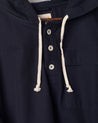 Closer front view of Uskees midnight blue smock with focus on front buttons, neck drawstring and breast pocket.