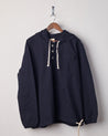 Front view of midnight blue coloured buttoned smock from Uskees with deep front pockets. Presented on hanger with white backdrop.