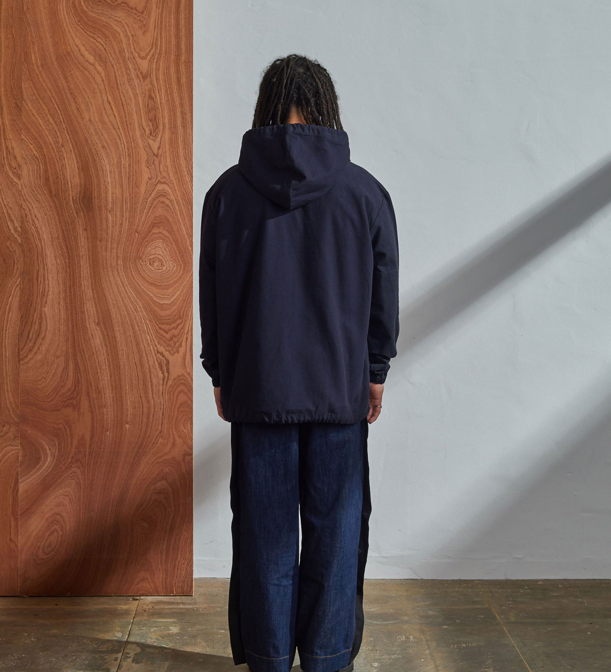 Full-length back view of model wearing Uskees midnight blue coloured buttoned smock.