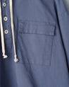 Close-up of teal coloured buttoned smock from Uskees with focus on right breast pocket.