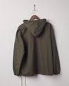 Back view of 'vine green' coloured buttoned smock from Uskees with view of hood. Presented on hanger with white backdrop.