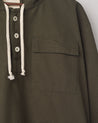 Closer front view of Uskees 'vine green' smock with focus on front buttons, neck drawstring and breast pocket.