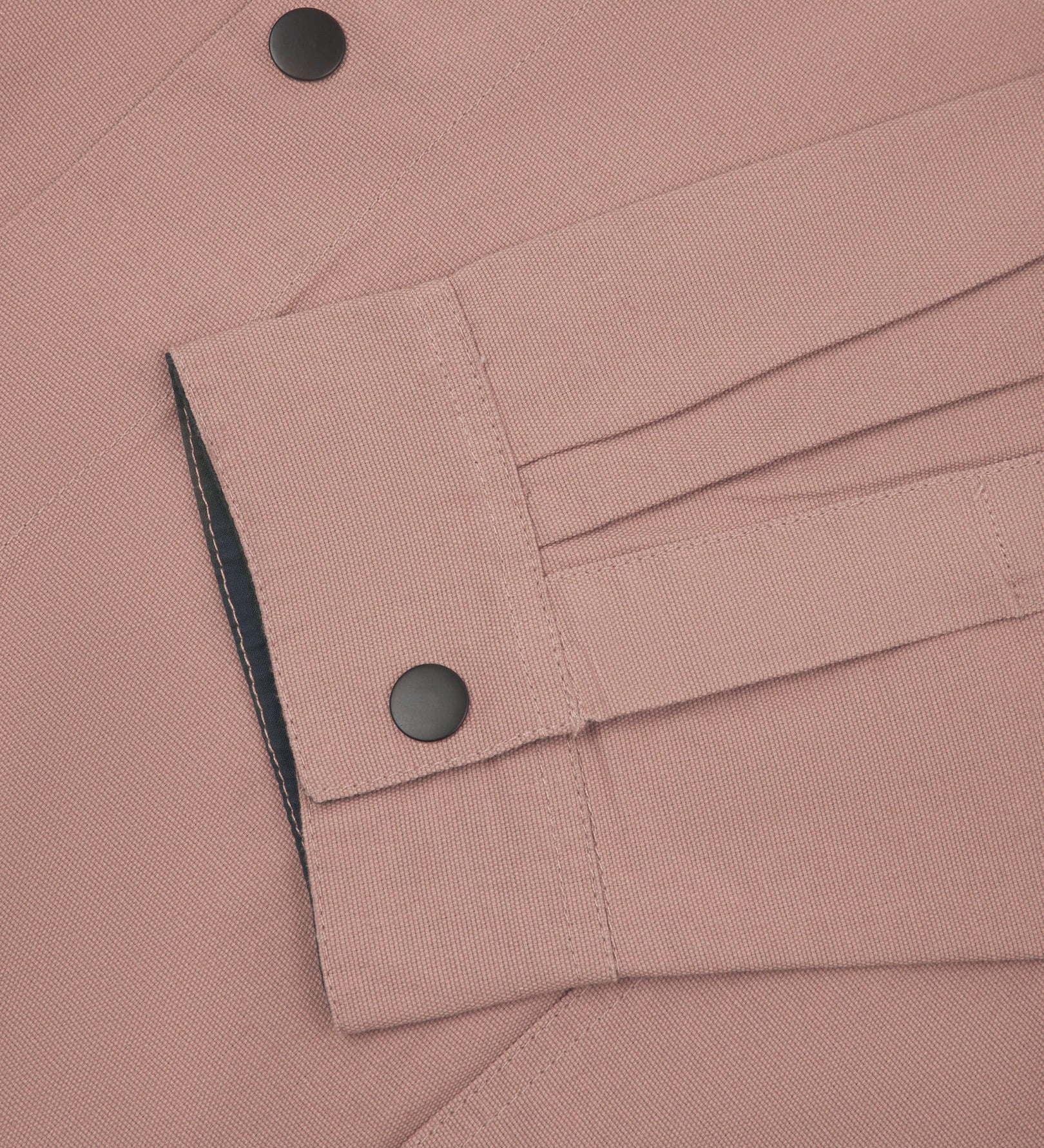 Sleeve view of Uskees 3013 dusty pink organic cotton coach jacket with focus on placket, cuff and popper buttons.