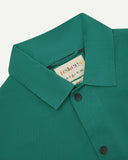 Neck view of Uskees 3013 foam green organic cotton coach jacket with focus on collar, contrast inner yoke, Uskees brand label and popper buttons.