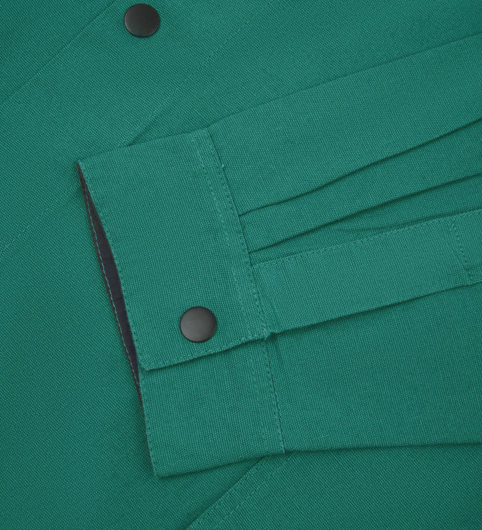 Sleeve view of Uskees 3013 foam green organic cotton coach jacket with focus on placket, cuff and popper buttons.