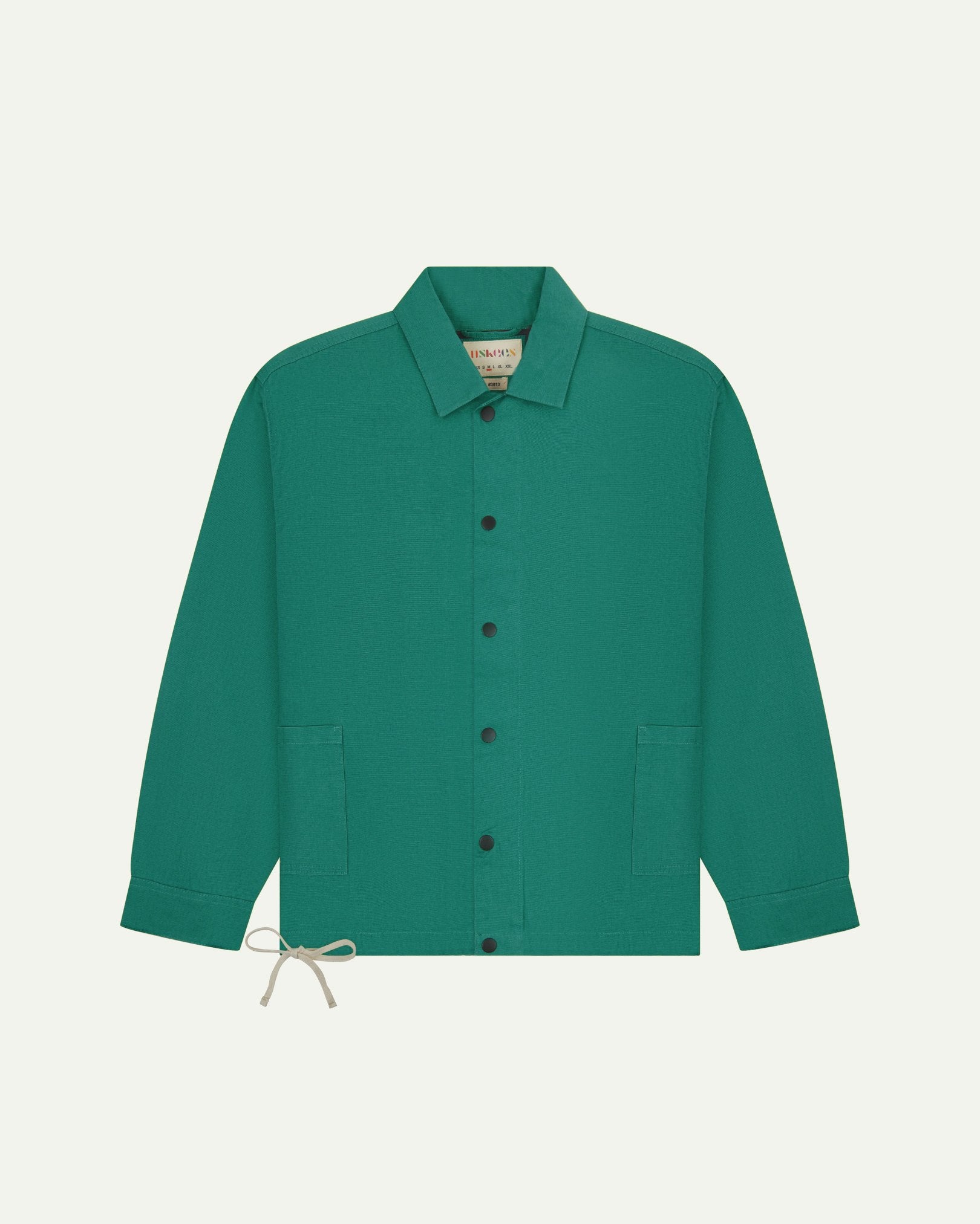 Full front view of Uskees foam green organic cotton coach jacket showing sharp, contemporary detailing including 2 patch pockets, drawstring base and popper fastening.