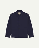 Full front view of Uskees dark blue organic cotton coach jacket with 2 patch pockets and drawstring base.