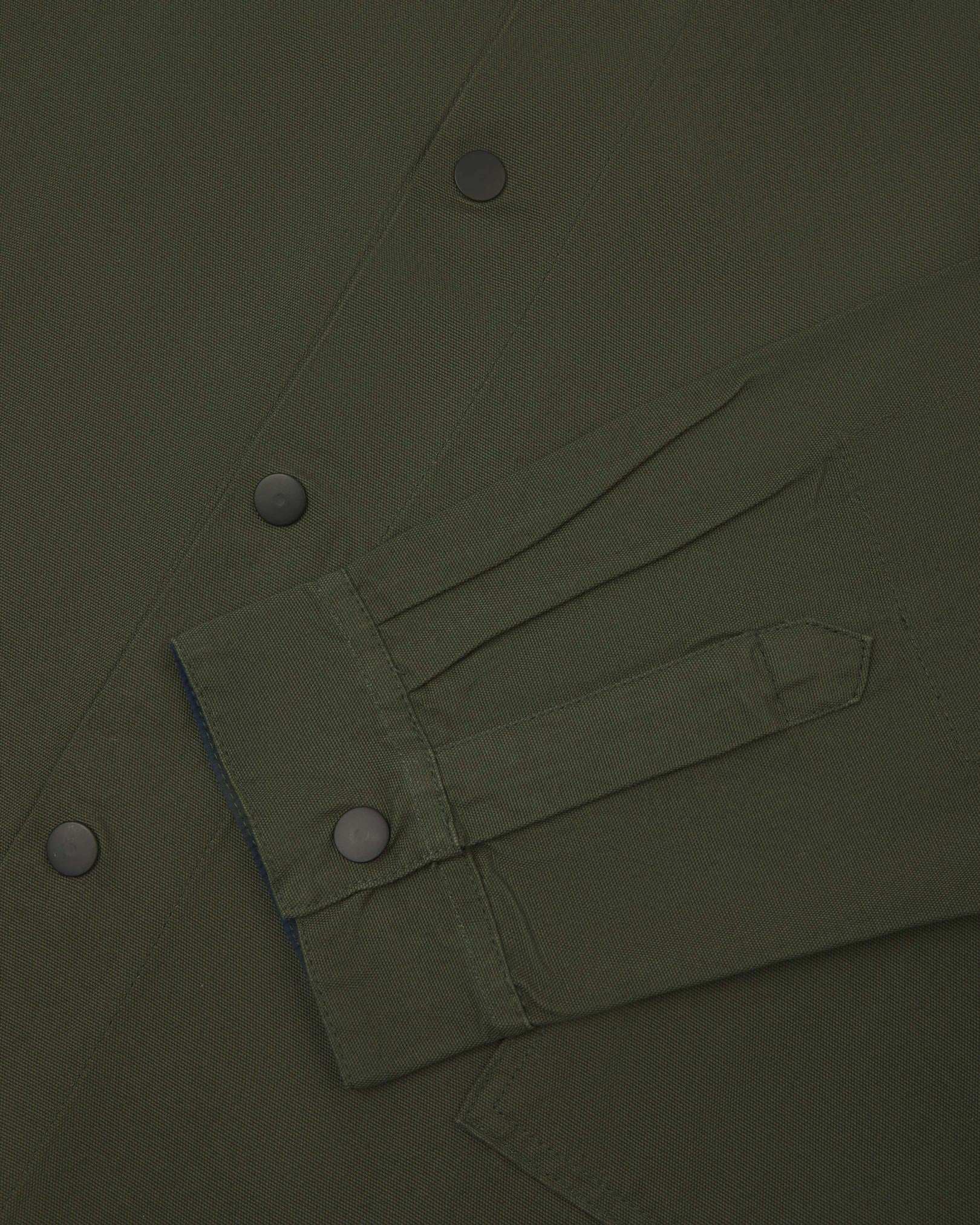 Sleeve view of Uskees 3013 vine green organic cotton coach jacket with focus on placket, cuff and popper buttons.