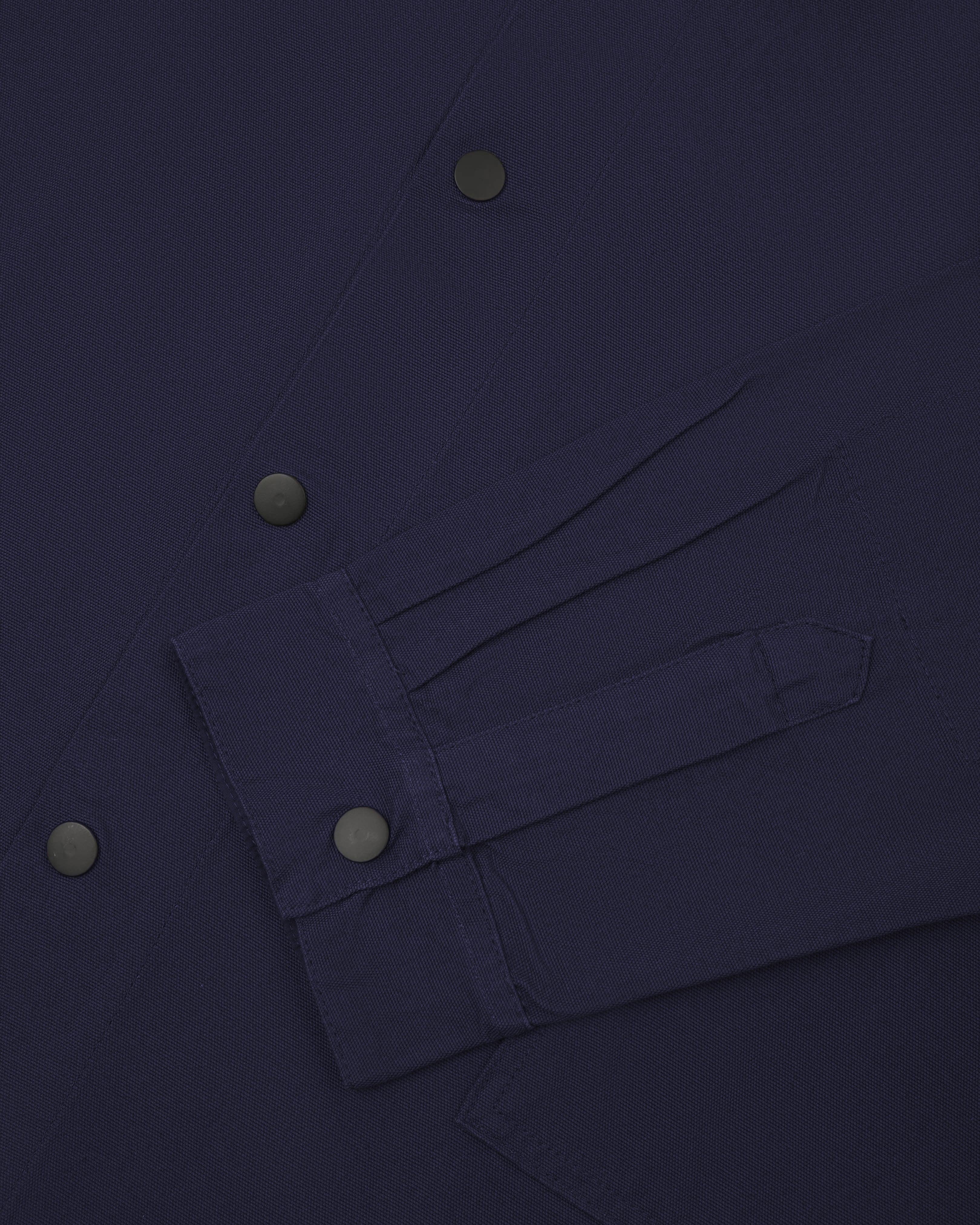  Close up shot of cuff and front popper fastening of Uskees #3013 coach jacket in midnight blue.