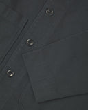 Close up view of charcoal-grey organic cotton drill commuter blazer showing front buttons and cuff detail.