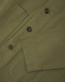Front close view of moss green organic cotton drill commuter blazer showing cuff/sleeve, corozo buttons & patch pocket