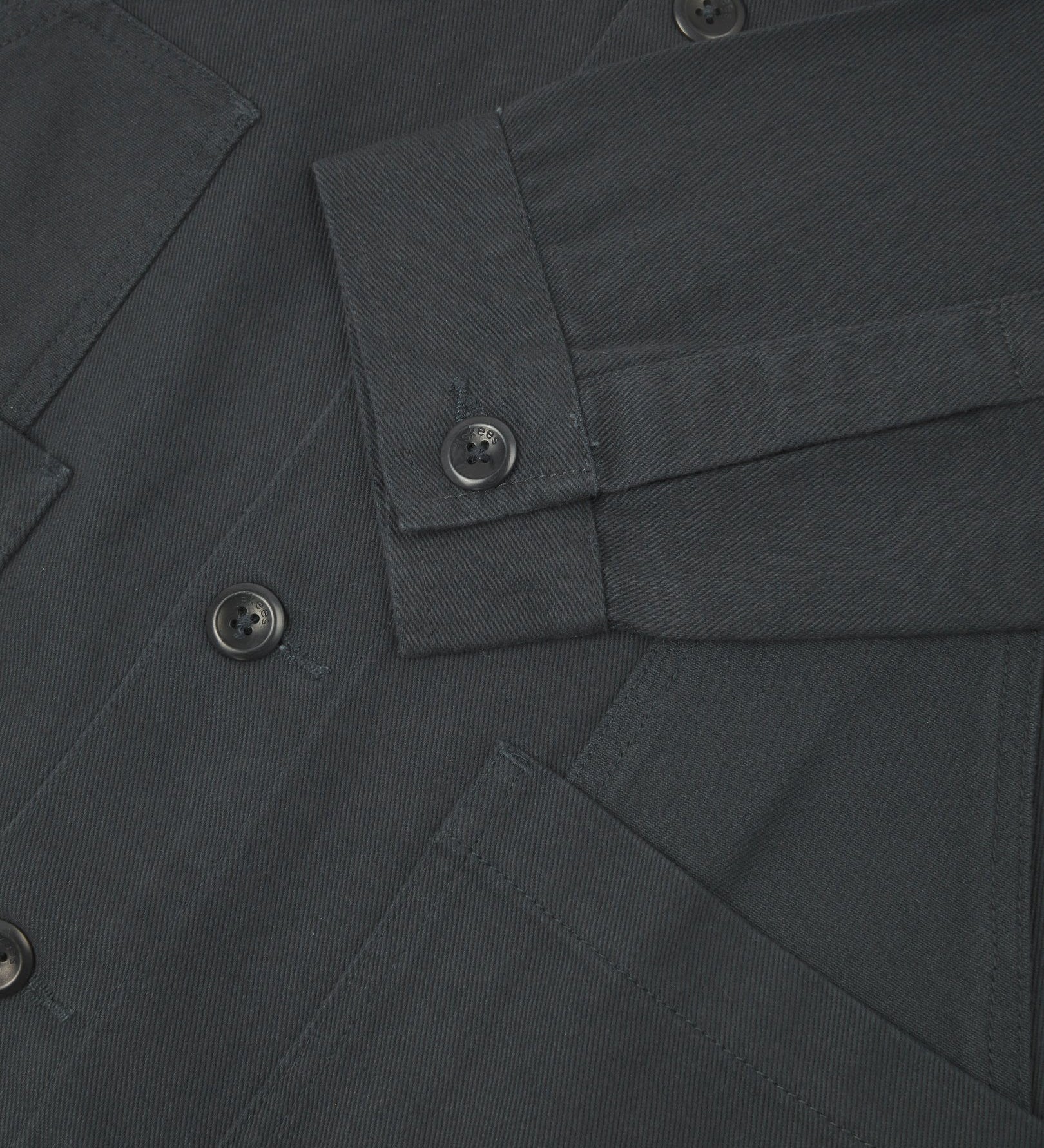 Closer detail view of multi-layered patch pockets, cuff detailing, corozo buttons and extra durable weave of the organic cotton heavyweight drill fabric.