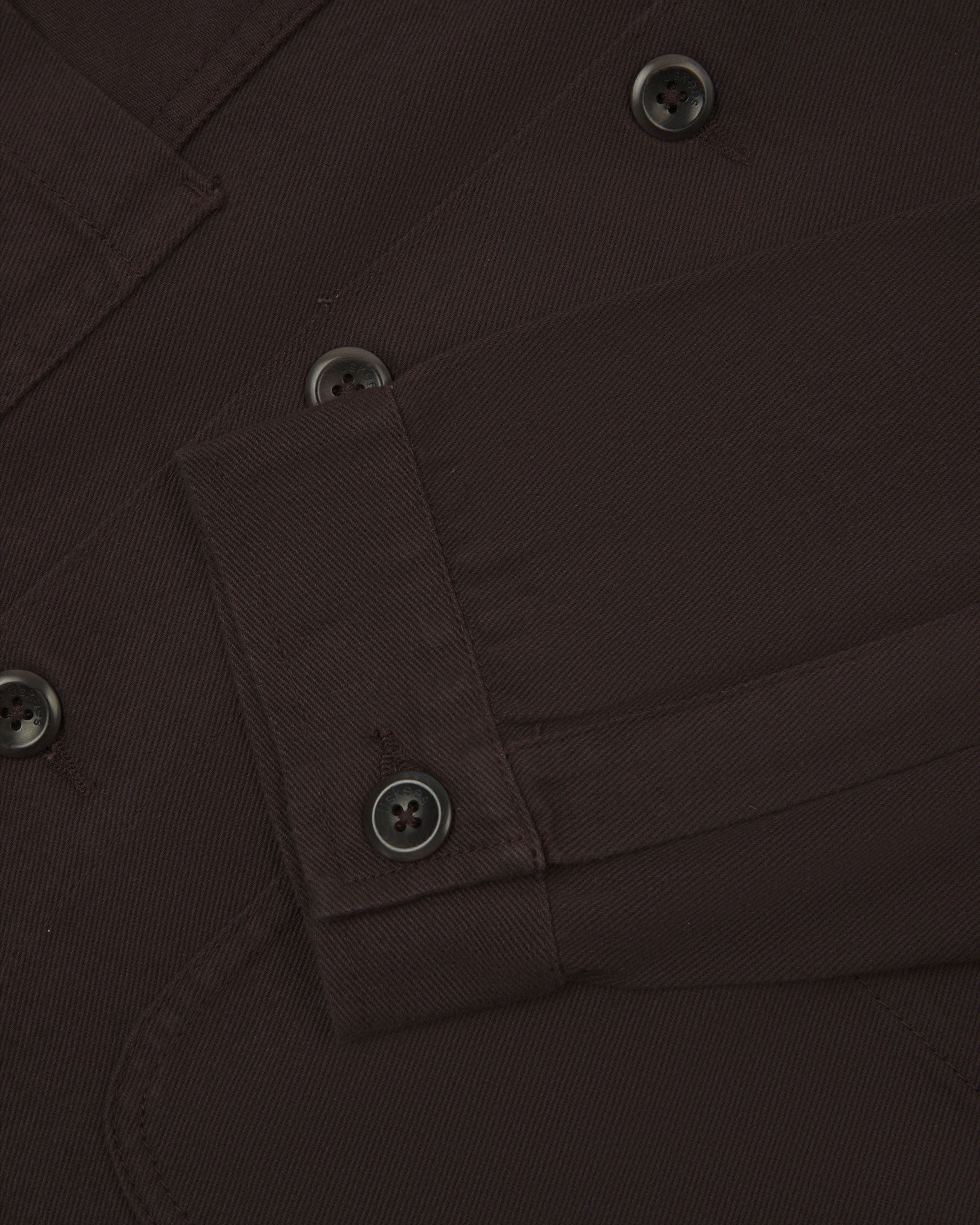 Closer detail view of multiple layered patch pockets, cuff detailing, corozo buttons and extra durable weave of the organic cotton drill fabric.