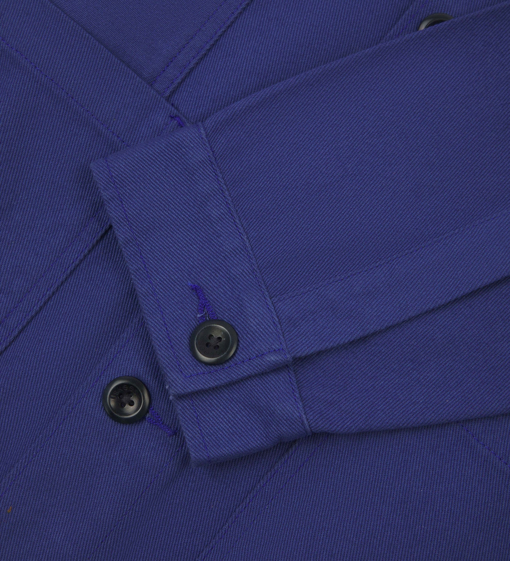 Closer detail view of multiple layered patch pockets, cuff detailing, corozo buttons and extra durable weave of the organic cotton drill fabric.