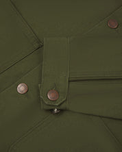 Close-up view of Uskees cotton canvas chore jacket in coriander green showing the adjuster buttons on the cuffs