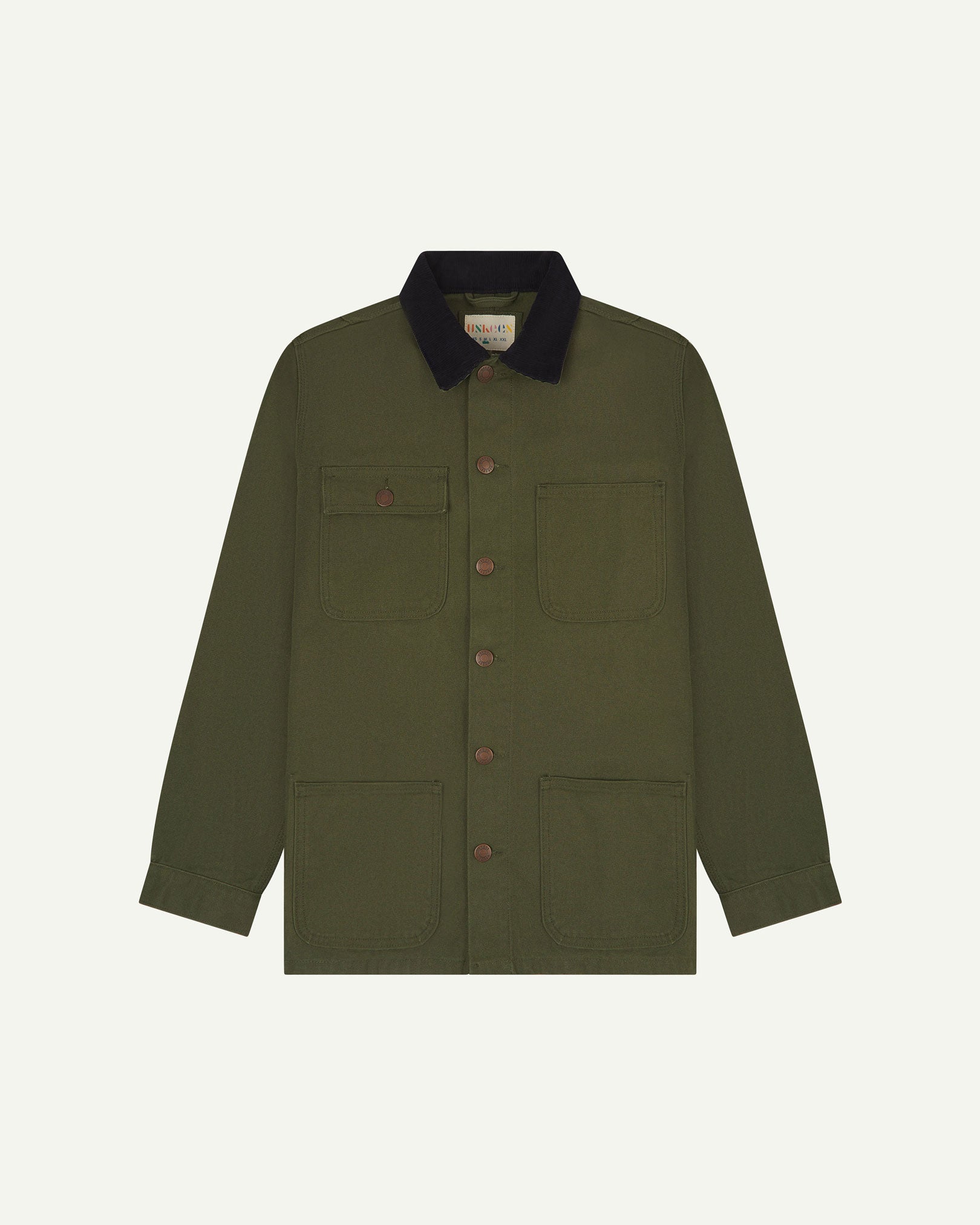 Front flat shot of Uskees cotton canvas chore jacket in coriander green with a navy blue collar. Clear view of the pockets and buttons.