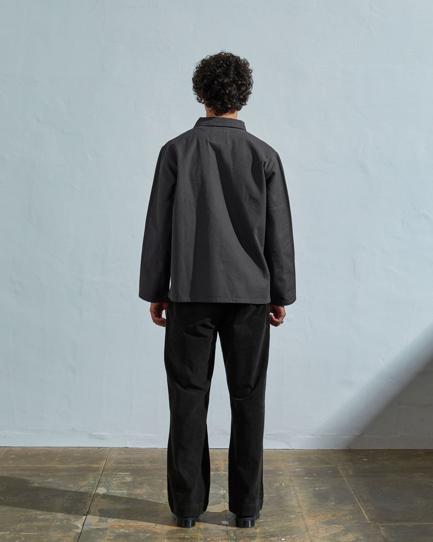 Full-length back view of model wearing 3027 charcoal-coloured organic canvas overshirt.