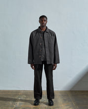 Full-length front view of model wearing #3027 charcoal-coloured organic canvas overshirt with deadstock metal buttons undone.