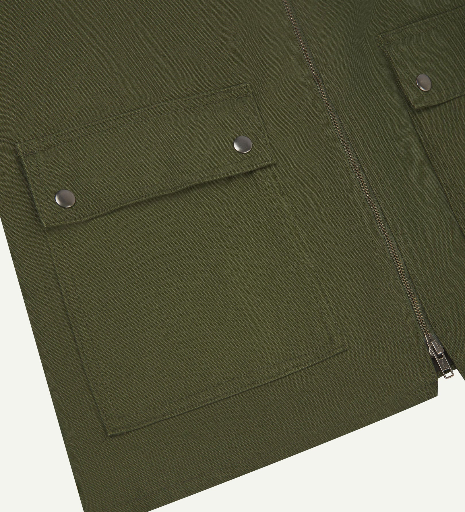Front flat close-up shot of Uskees coriander-green zip front vest-waistcoat showing the front flap pockets with metal poppers and double-ended zip