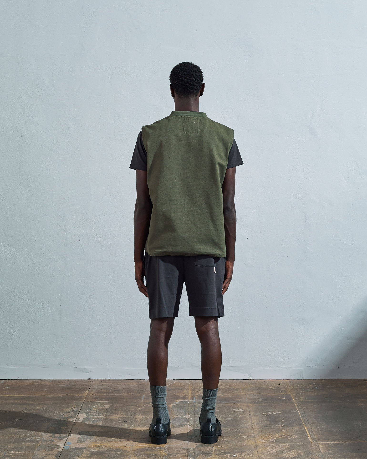 Full-length rear view of #3029, coriander-coloured organic canvas vest.
