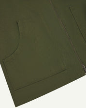 Front flat close-up shot of Uskees coriander green zip front vest-waistcoat showing the front cut-away patch pockets and double-ended zip.
