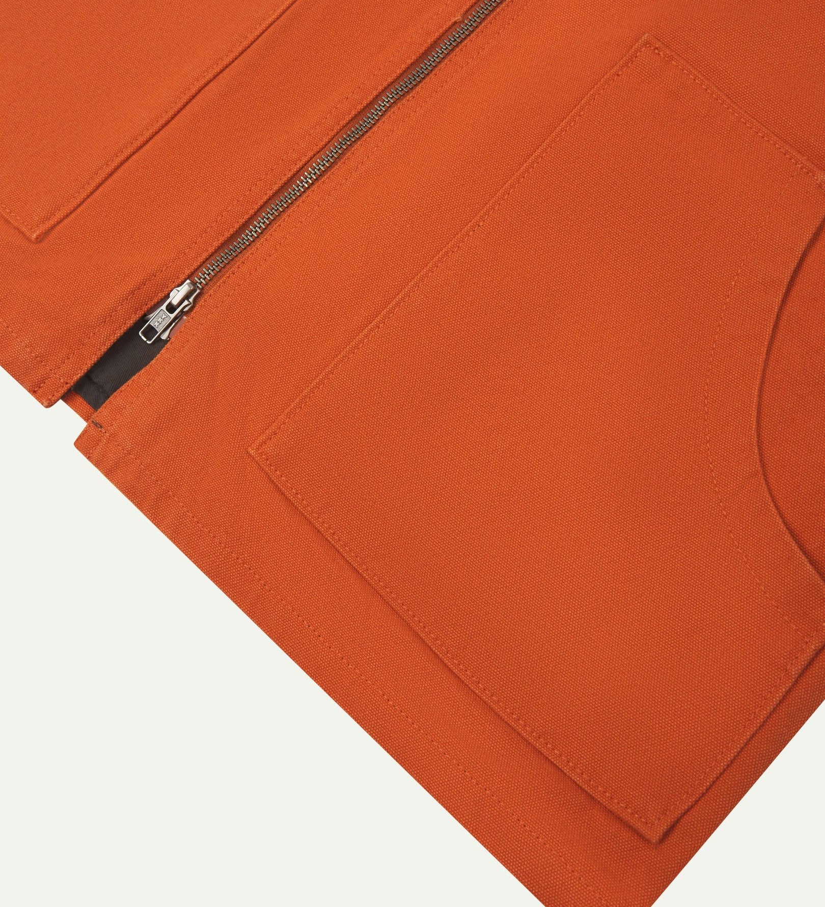 Front flat close-up shot of Uskees golden-orange zip front vest-waistcoat showing the front cut-away patch pockets and double-ended zip.