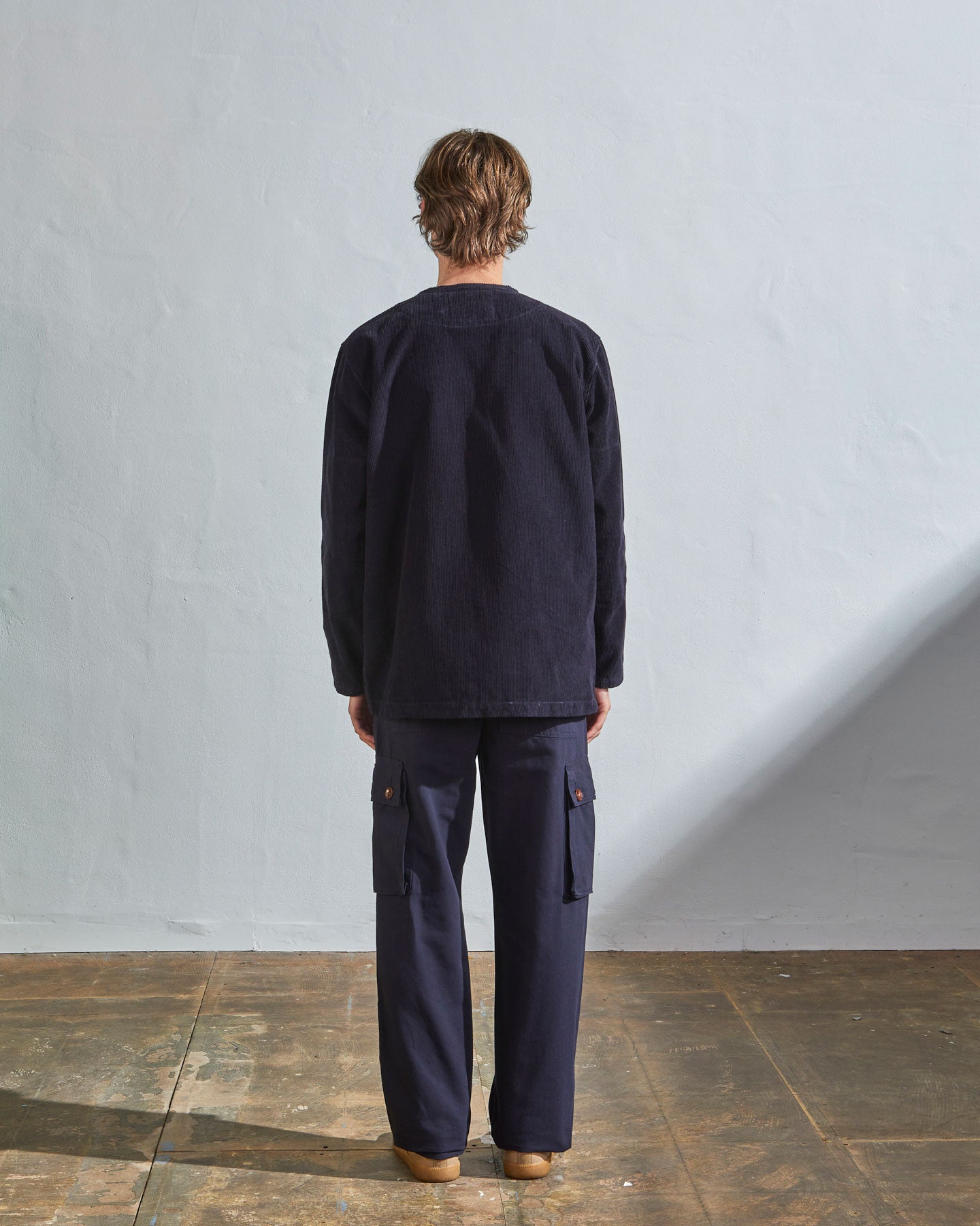 Full-length back view model wearing #5030 Uskees 'midnight blue' collarless corduroy jacket, emphasising boxy, contemporary silhouette.
