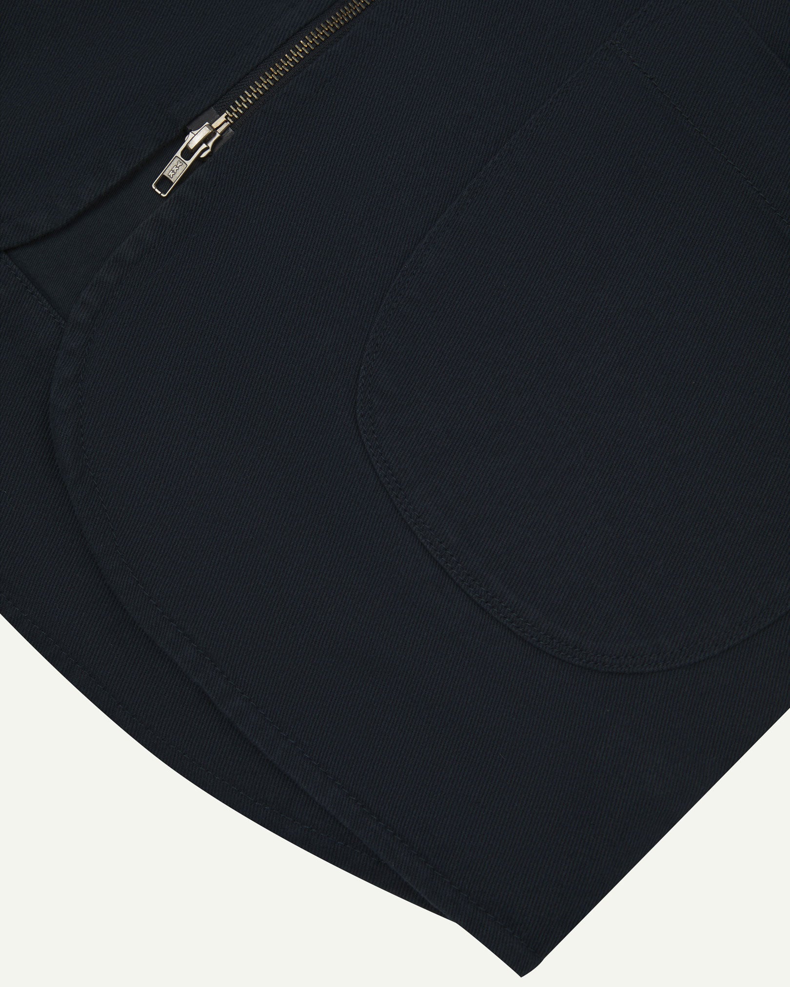 Close-up bottom-half view of #3036 dark blue (blueberry) organic cotton-drill vest with focus on curved pocket detail.