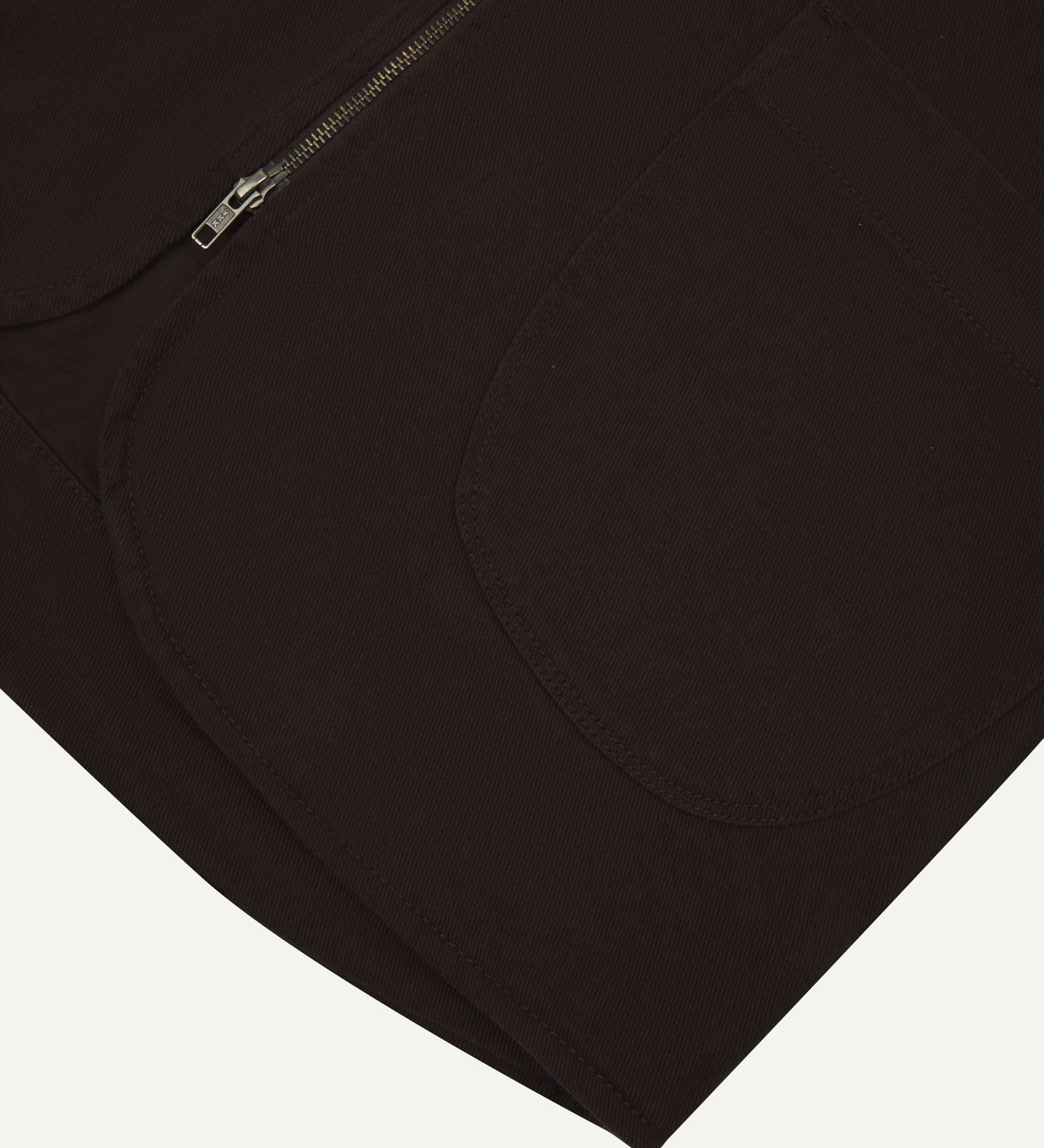 Close-up bottom-half view of #3036 burgundy-brown organic cotton-drill vest with focus on curved pocket detail.
