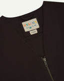 Close-up top-half view of #3036 burgundy-brown organic cotton-drill vest. With focus on v-neck, contrasting black lining and Uskees branding label.