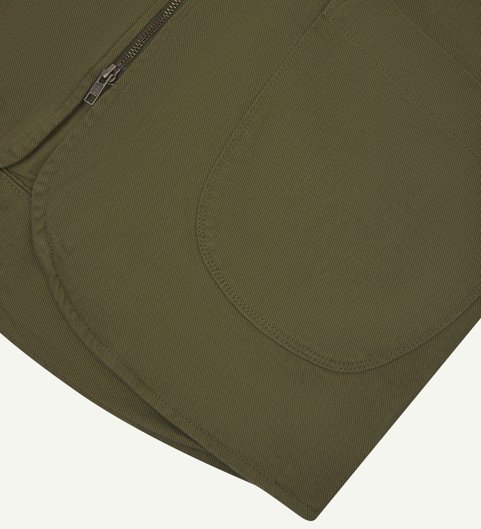 Close-up bottom-half view of #3036 moss-green organic cotton-drill vest with focus on curved pocket detail.