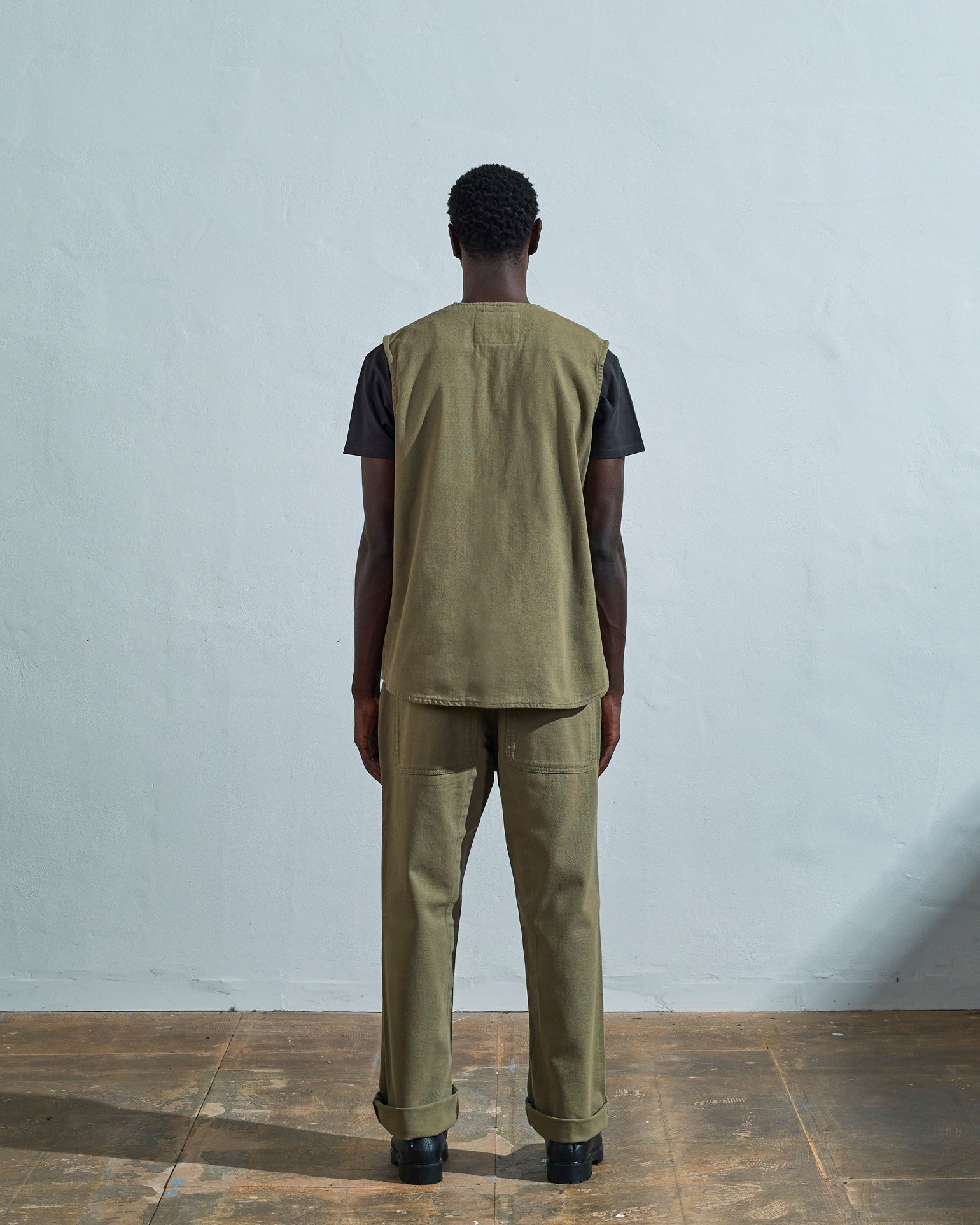 Full-length rear view of #3036, moss-green organic cotton-drill vest from Uskees.