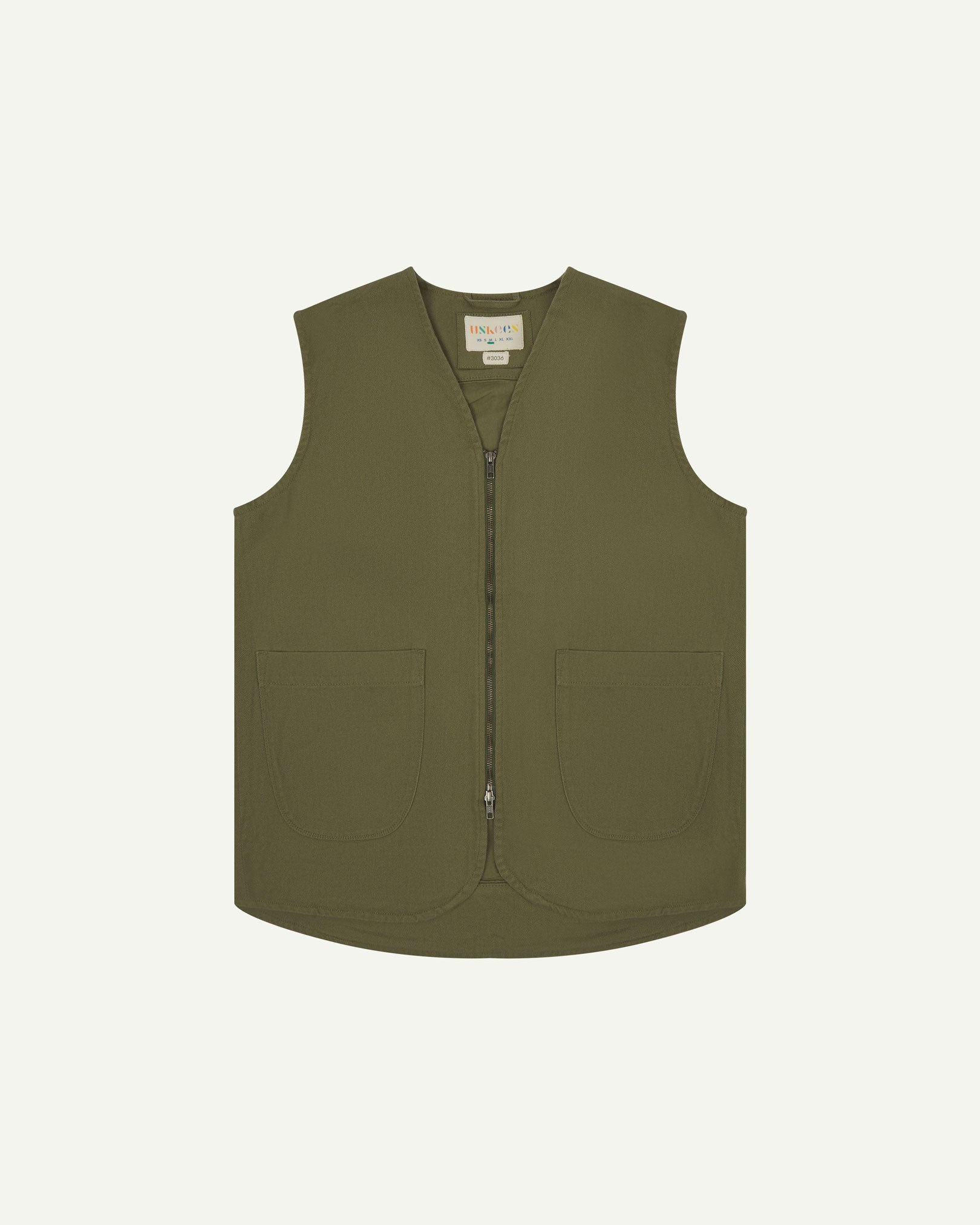 Full-length front view of Uskees #3036 moss-green organic cotton-drill vest. Fully zipped and showing clear view of curved patch pockets and branding label.