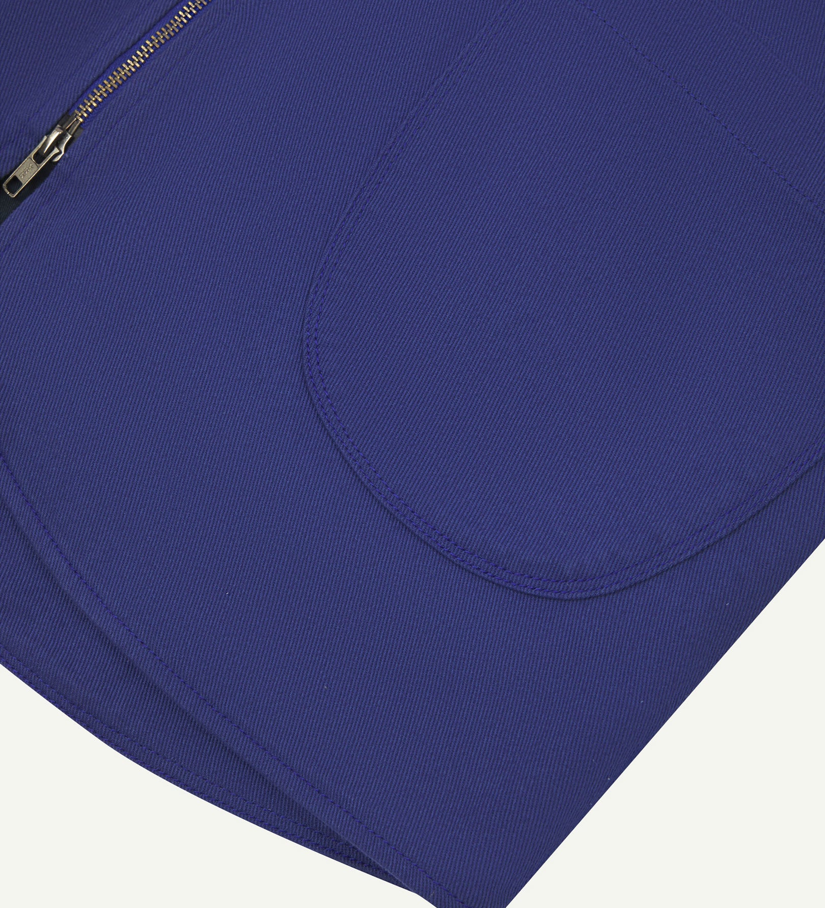 Close-up bottom-half view of #3036 ultra blue organic cotton-drill vest with focus on curved pocket detail.