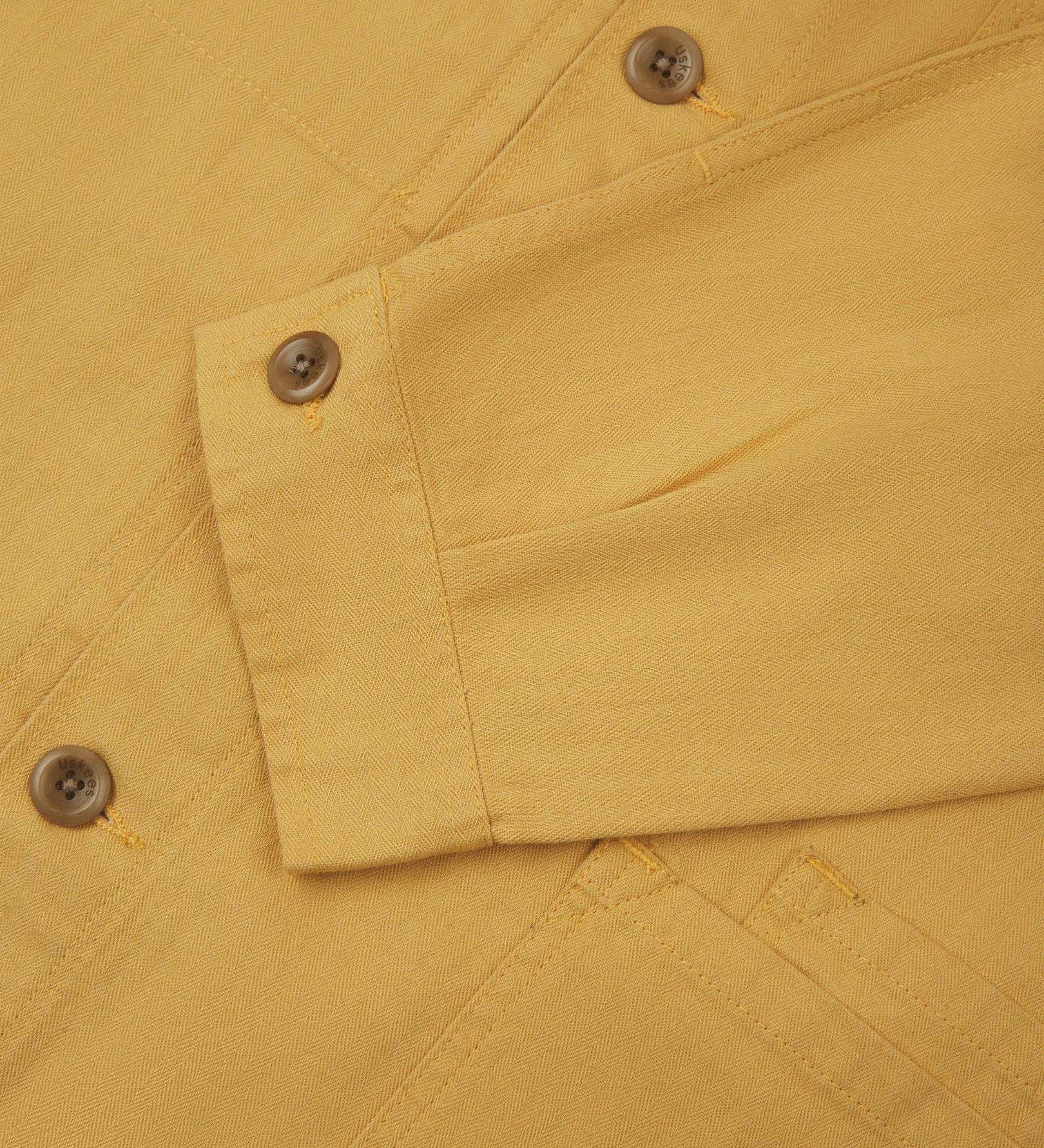 Sleeve view of Uskees 3040 sandstone-yellow herringbone cotton engineer jacket with focus on placket, buttoned cuff and ticket pocket.