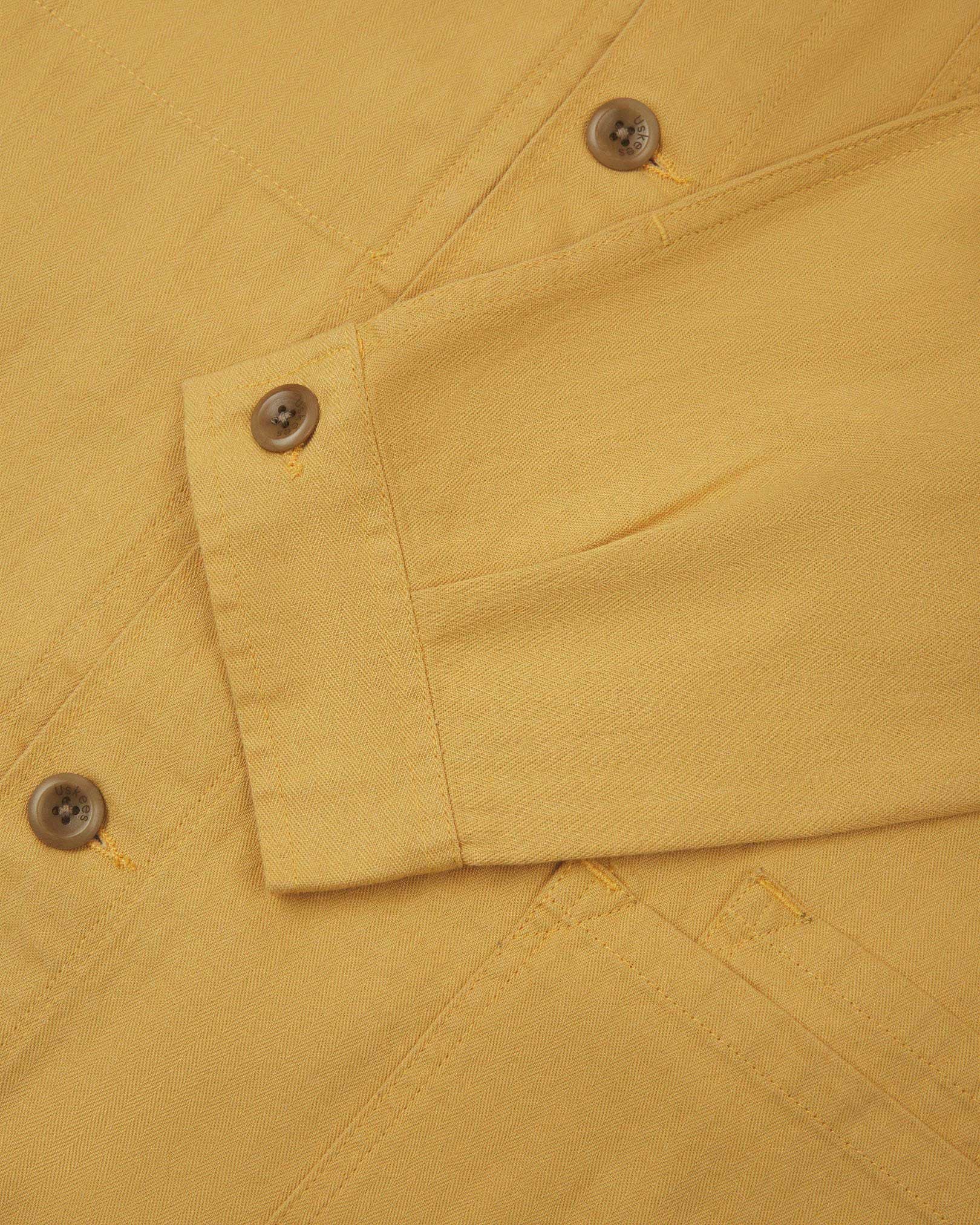 Sleeve view of Uskees 3040 sandstone-yellow herringbone cotton engineer jacket with focus on placket, buttoned cuff and ticket pocket.