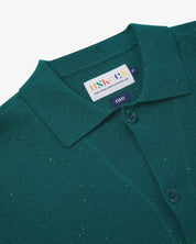 Close-up front view of knitted organic cotton foam green cardigan showing the collar, corozo buttons and Uskees branding label.