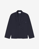 Flat front view of knitted organic cotton midnight blue blazer with 3 patch pockets from Uskees. Clearly showing corozo buttons, two branding labels and 3 pockets on the front.