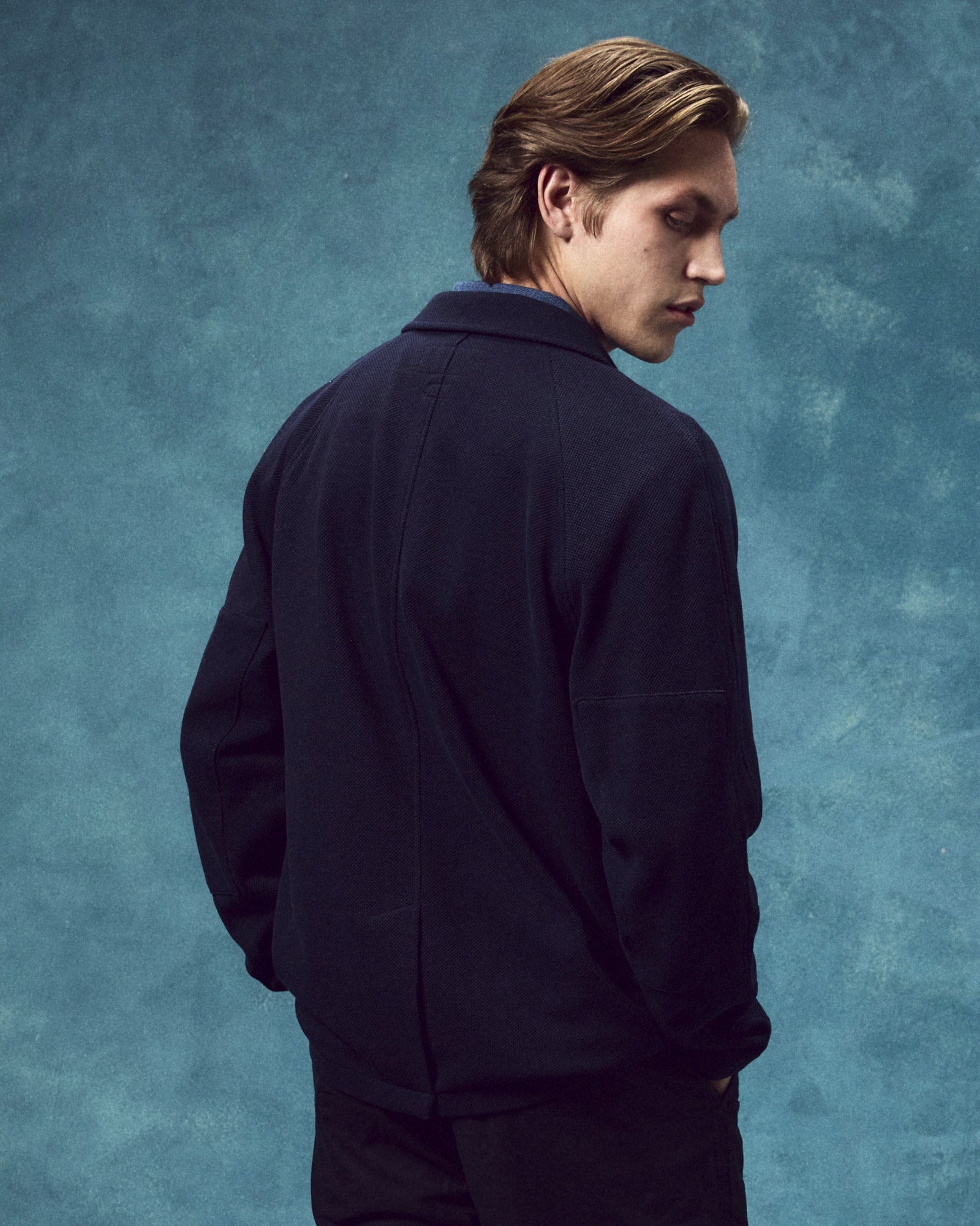 Back view of man wearing the #3044 knitted blazer in midnight blue, showing the back vent and reinforced elbows.