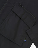 Close up view of Uskees black ripstop field jacket with focus on a zip and gusseted chest pocket, cuff and small branding tab.