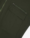 Close-up of an Uskees vine green field jacket for men showing a pocket and zipper detail on a white background