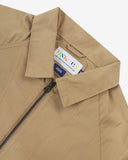 Close-up shot of a beige Uskees ripstop fabric jacket with a brand label inside the collar on a white background