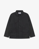 Front view of Uskees black ripstop utility jacket showing the chest zip pocket and two gusseted hip pockets with flaps.