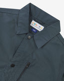 Close up view of Uskees blueberry ripstop utility jacket with focus on the collar, popper button and branding label.