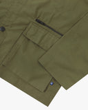 Close up view of Uskees ivy green ripstop utility jacket with focus on a hip pockets, zip pocket and reinforced elbows.