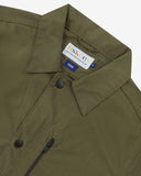 Close up view of Uskees ivy green green ripstop utility jacket with focus on the collar, popper button and branding label.